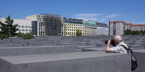Germany, Berlin, Holocaust Memorial, Senior man photographing steles - WIF000950