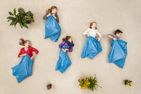 Kinder beim Sackhüpfen in Müllsäcken - BAEF000724