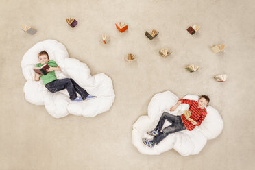 Jungen liegen auf Wolken und lesen - BAEF000748