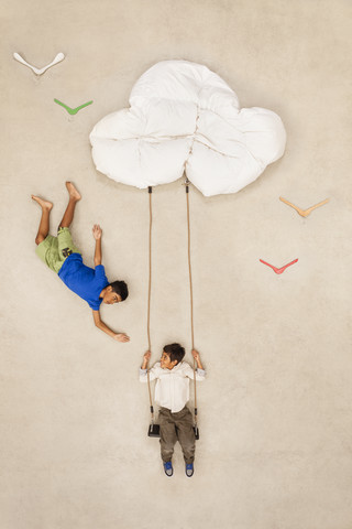 Auf Wolken schaukelnde Kinder, lizenzfreies Stockfoto