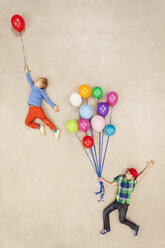 Kinder fliegen an Luftballons davon - BAEF000903