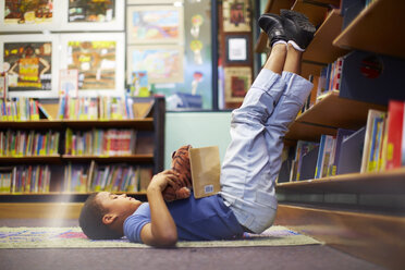 Junge auf dem Boden liegend in der Bibliothek - ZEF000192