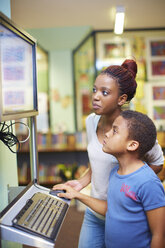 Junge Frau und Junge benutzen Computer in einer Bibliothek - ZEF000205