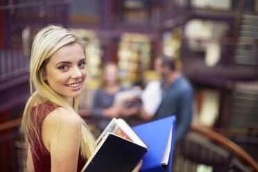 Porträt einer lächelnden Studentin in einer Bibliothek - ZEF000085