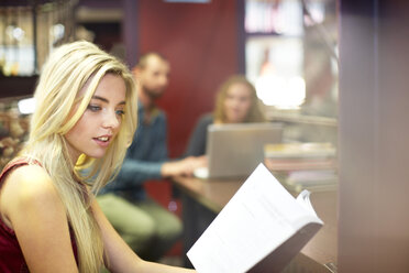 Studentin beim Lesen eines Buches in einer Bibliothek - ZEF000764