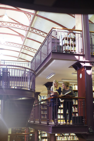 Zwei Studentinnen lernen in einer Bibliothek, lizenzfreies Stockfoto