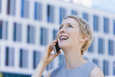 Lächelnde blonde Frau beim Telefonieren mit Smartphone - TCF004295