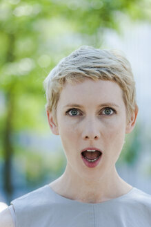 Porträt einer verblüfften blonden Frau mit offenem Mund - TCF004310