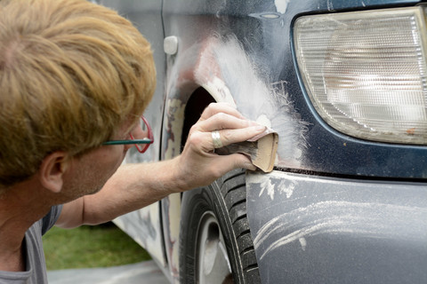Germany, Zeuthen, Man mending car paint stock photo