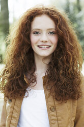 Porträt eines lächelnden Mädchens mit lockigem rotem Haar - GDF000405