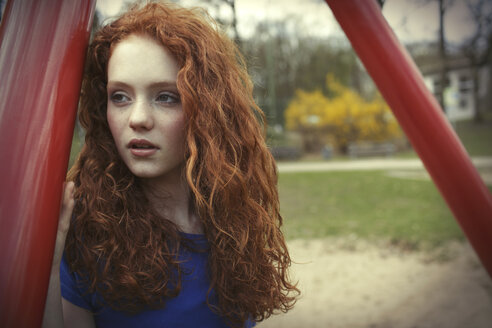 Porträt eines Mädchens mit lockigem rotem Haar auf einem Spielplatz - GDF000408