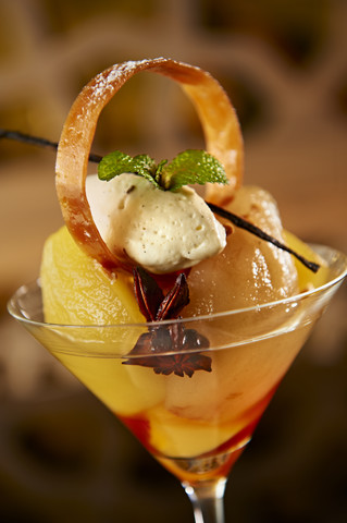 Mango-Dessert mit Ananas-Mousse und Sternanis in einem Cocktailglas, lizenzfreies Stockfoto