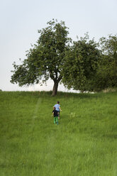 Two boys running on a meadow uphill - PAF000857