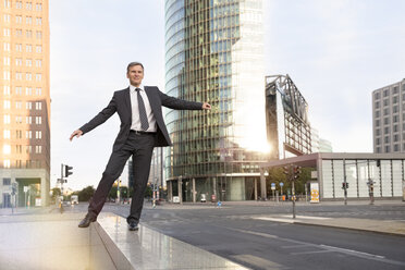 Germany, Berlin, Businessman balancing on balustrade - FKF000610