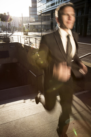 Deutschland, Berlin, Geschäftsmann läuft auf Treppe, lizenzfreies Stockfoto