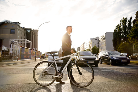 Deutschland, Berlin, Geschäftsmann beim Radfahren in der Stadt, lizenzfreies Stockfoto