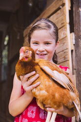 Deutschland, Nordrhein-Westfalen, Bornheim, Mädchen mit Huhn im Arm - MFF001171