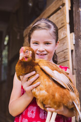 Germany, Northrhine Westphalia, Bornheim, Girl holding chicken in arms - MFF001171