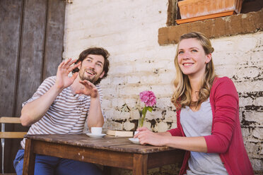 Germany, Northrhine Westphalia, Bornheim, Couple sitting in courtyard, drinking coffee - MFF001187