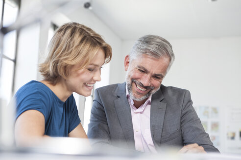 Zwei Kollegen besprechen etwas in einem Büro - RBF001817