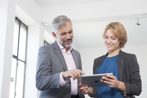 Two colleagues with digital tablet in an office - RBF001861