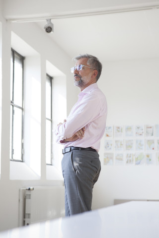 Businessman with crossed arms standing in an office stock photo