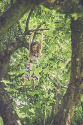 Little girl climbing on a tree in the garden - SARF000783
