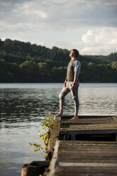 Germany, Rhineland-Palatinate, Laach Lake, Man standing on wooden boardwalk - PAF000911