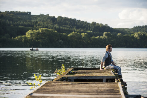 Deutschland, Rheinland-Pfalz, Laacher See, Mann sitzt auf Holzpromenade - PAF000912