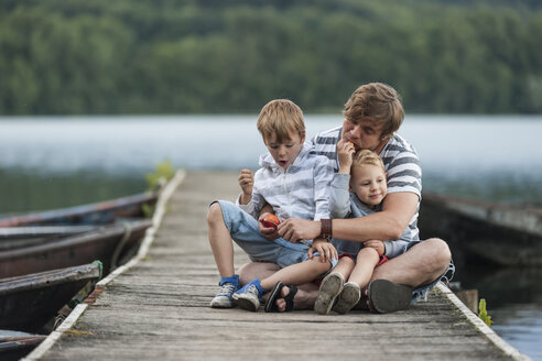 Deutschland, Rheinland-Pfalz, Laacher See, Vater sitzt mit zwei Söhnen am Steg - PAF000922