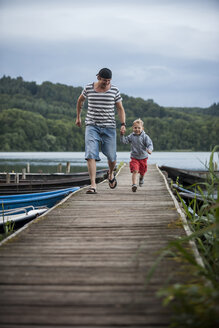 Deutschland, Rheinland-Pfalz, Laacher See, Vater läuft mit Sohn auf Steg - PAF000925