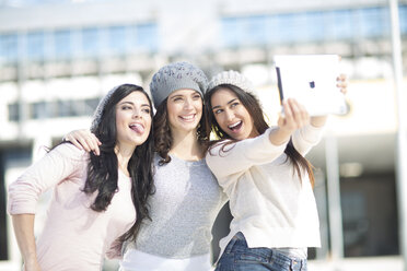 Drei Freundinnen mit Wollmützen machen ein Selfie mit digitalem Tablet - ZEF000798