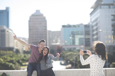 Woman photographing happy young couple with smartphone - ZEF000807