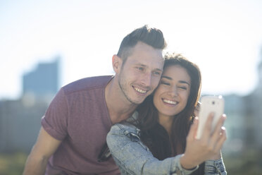 Porträt eines glücklichen jungen Paares, das ein Selfie mit einem Smartphone macht - ZEF000808