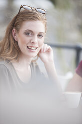 Porträt einer lächelnden jungen Frau in einer Kaffeepause - ZEF000328