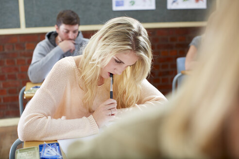 Studentin im Klassenzimmer beim Schreiben am Schreibtisch - ZEF000741
