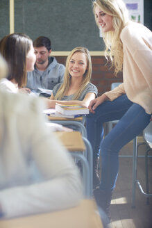 Lächelnde Studentinnen im Gespräch im Klassenzimmer - ZEF000669