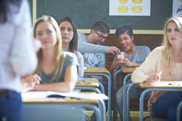 Verspielte Schüler mit Handy im Klassenzimmer - ZEF000683