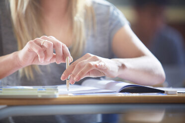 Studentin im Klassenzimmer beim Schreiben am Schreibtisch - ZEF000687