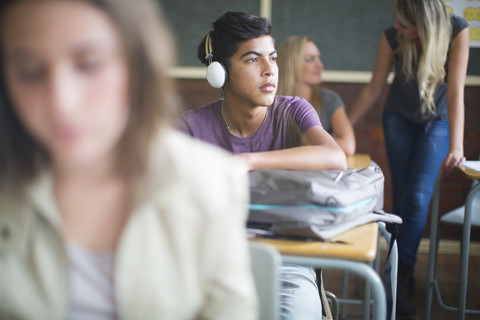 Schüler trägt Kopfhörer im Klassenzimmer, lizenzfreies Stockfoto