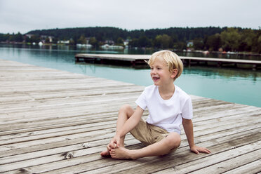 Porträt eines lächelnden kleinen Jungen, der auf einem Steg sitzt - DAWF000113