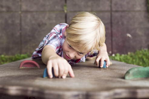 Porträt eines kleinen Jungen, der auf einem Spielplatz klettert - DAWF000136