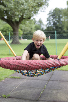 Porträt eines kleinen Jungen, der sich auf einem Spielplatz vergnügt - DAWF000140