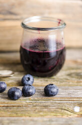 Preserving jar of selfmade blueberry jam on wood - ODF000816