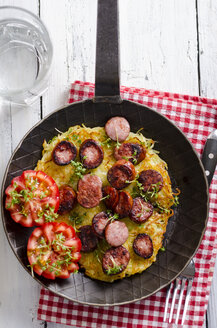 Frying pan of potato roesti garnished with slices minced pork sausage and tomatoes - ODF000818