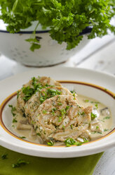 Slices of selfmade napkin dumplings with champignon sauce and parsley - ODF000810