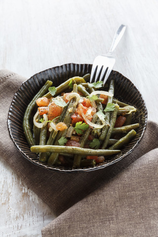 Schüssel mit vorbereiteten grünen Bohnen, Tomaten und Zwiebeln auf einem Tuch, lizenzfreies Stockfoto