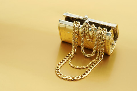 Open gold purse with gold jewelry stock photo