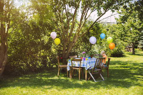 Partytisch im Garten mit kleinem Jungen, lizenzfreies Stockfoto