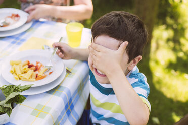 Junge, der seine Augen auf einer Gartenparty verdeckt - MFF001255